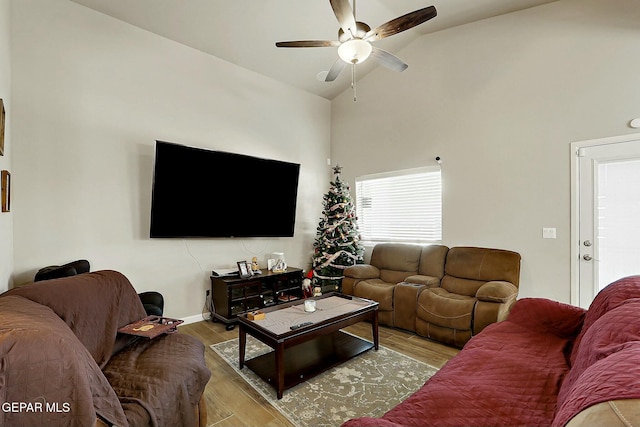 living room featuring ceiling fan, light hardwood / wood-style flooring, and lofted ceiling