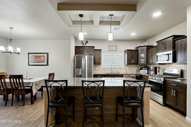 kitchen featuring sink, a center island, hanging light fixtures, and stainless steel appliances