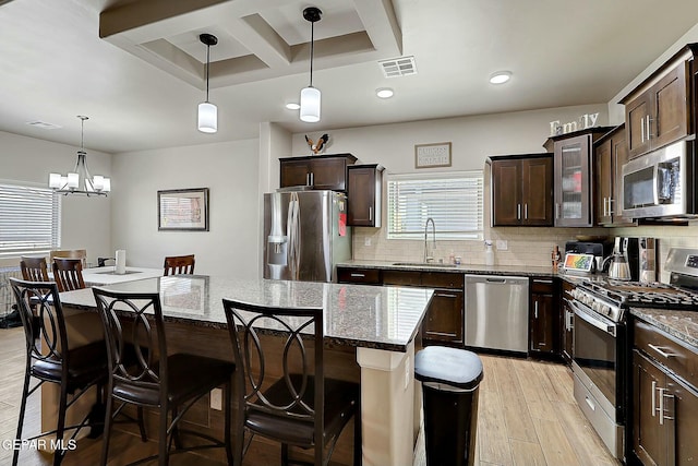 kitchen featuring decorative backsplash, sink, stainless steel appliances, and a kitchen island