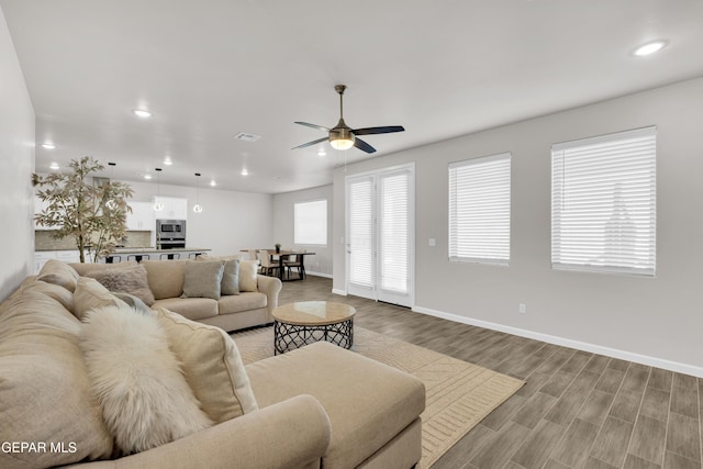 living room with ceiling fan and light wood-type flooring