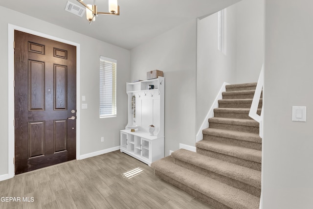 foyer entrance with wood-type flooring and a chandelier