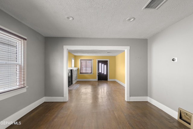 entryway with dark wood-type flooring and a textured ceiling