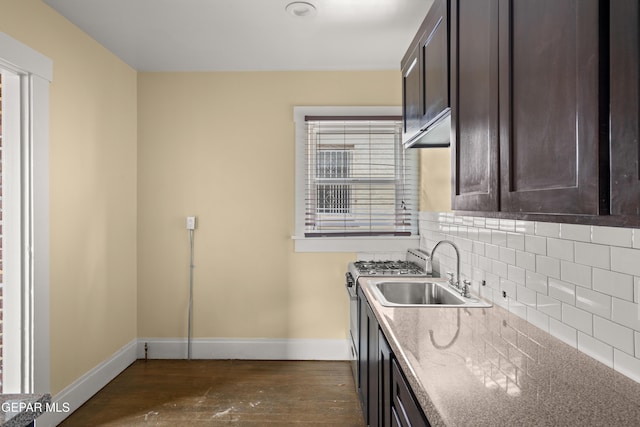 kitchen with sink, dark wood-type flooring, dark brown cabinetry, gas stove, and decorative backsplash