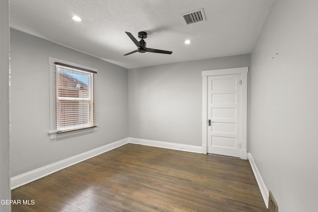 unfurnished room with a textured ceiling, dark wood-type flooring, and ceiling fan