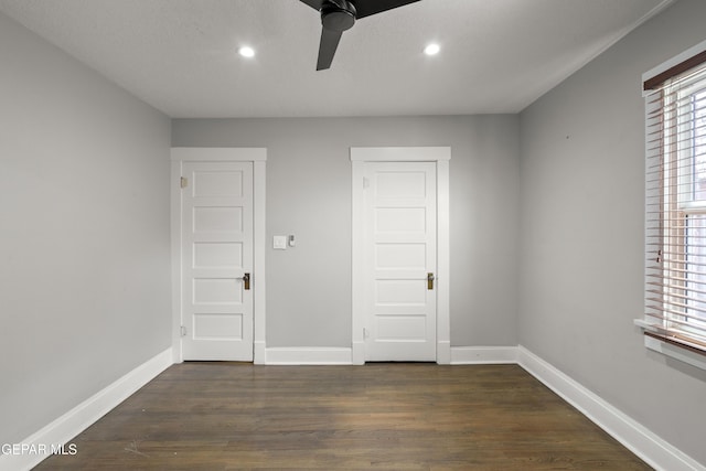 spare room featuring dark wood-type flooring and ceiling fan