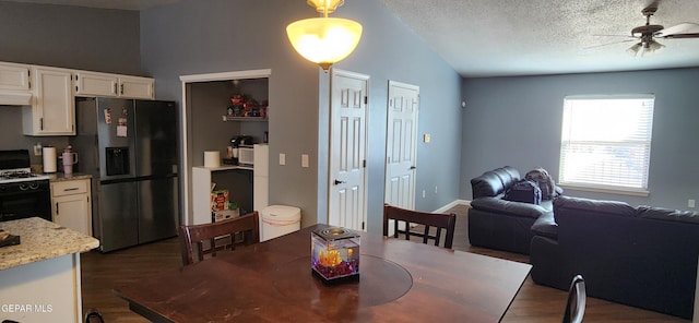 dining space featuring dark wood-type flooring, ceiling fan, lofted ceiling, and a textured ceiling