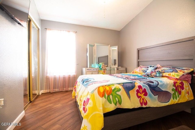 bedroom with hardwood / wood-style flooring, vaulted ceiling, and multiple windows