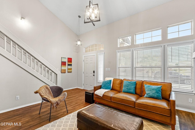 living room with hardwood / wood-style floors, an inviting chandelier, and high vaulted ceiling