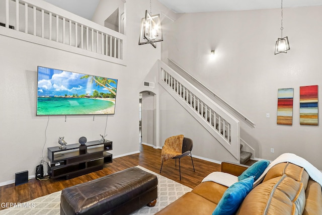 living room with high vaulted ceiling, dark hardwood / wood-style flooring, and a chandelier