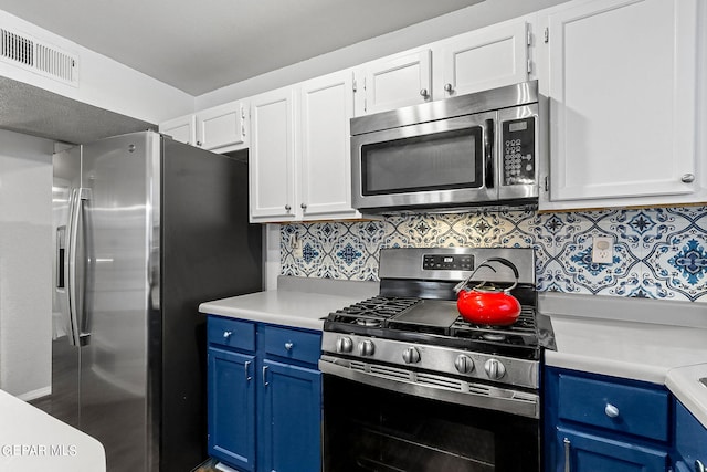 kitchen with blue cabinetry, decorative backsplash, white cabinets, and appliances with stainless steel finishes