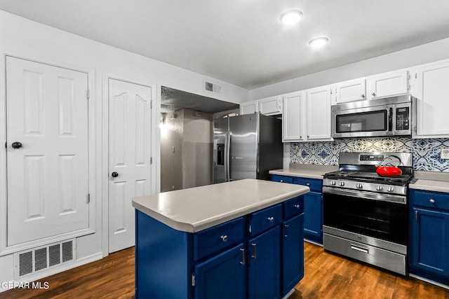 kitchen with a center island, blue cabinetry, appliances with stainless steel finishes, white cabinetry, and decorative backsplash