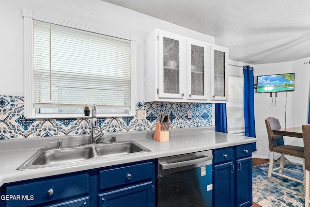 kitchen with sink, stainless steel dishwasher, white cabinetry, and blue cabinets