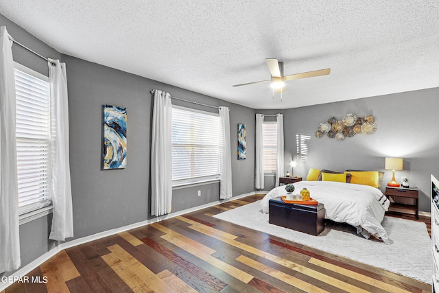 bedroom featuring wood-type flooring, a textured ceiling, and ceiling fan