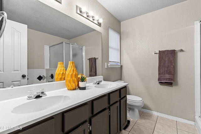 bathroom featuring toilet, a textured ceiling, an enclosed shower, tile patterned floors, and vanity