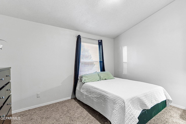 carpeted bedroom with a textured ceiling and vaulted ceiling