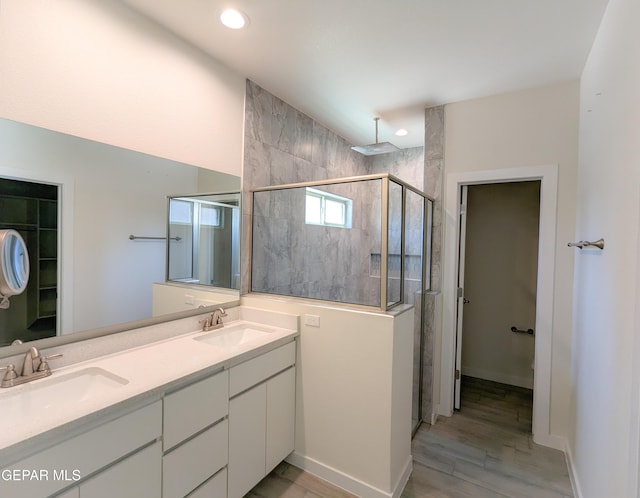 bathroom featuring walk in shower, vanity, and hardwood / wood-style flooring