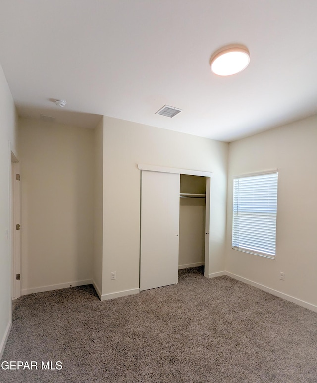 unfurnished bedroom featuring carpet floors and a closet