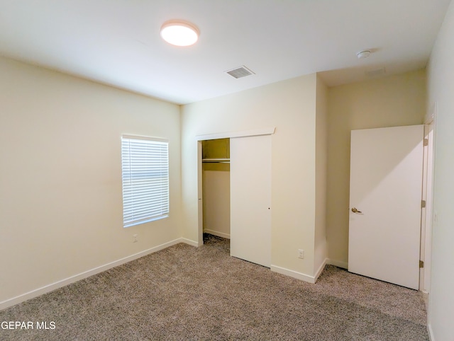 unfurnished bedroom featuring carpet flooring and a closet