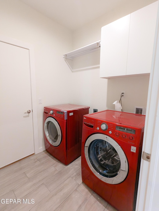 laundry area featuring cabinets and washer and clothes dryer