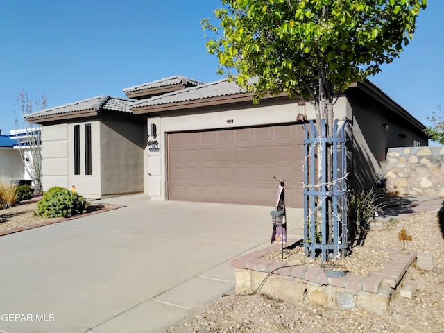 view of front of property with an attached garage, driveway, and stucco siding