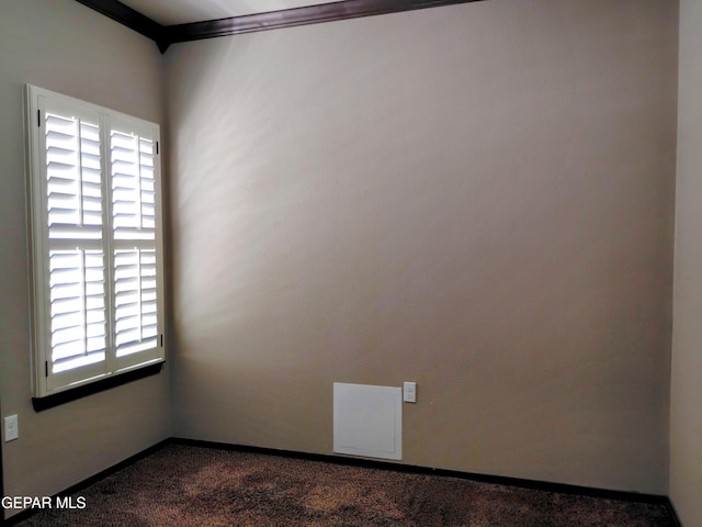 spare room with dark colored carpet and baseboards