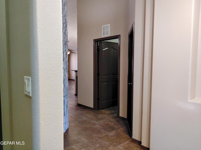 hall with dark tile patterned floors and visible vents
