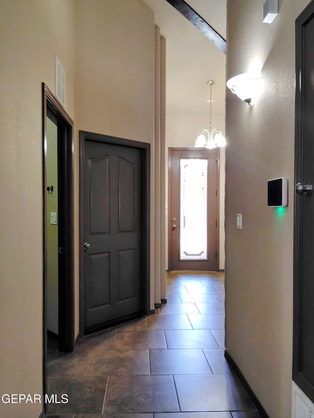 entrance foyer featuring an inviting chandelier, baseboards, and visible vents
