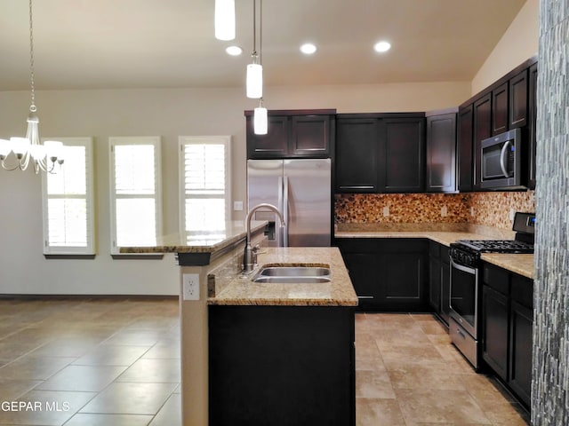kitchen with an inviting chandelier, light stone counters, backsplash, stainless steel appliances, and a sink