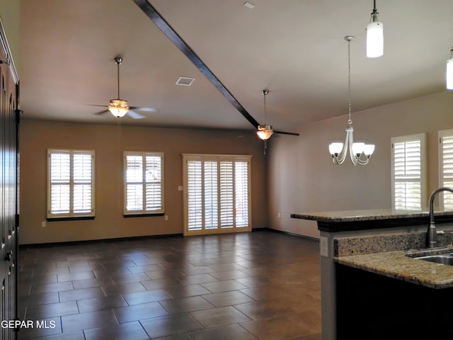 kitchen with open floor plan, ceiling fan with notable chandelier, and a sink