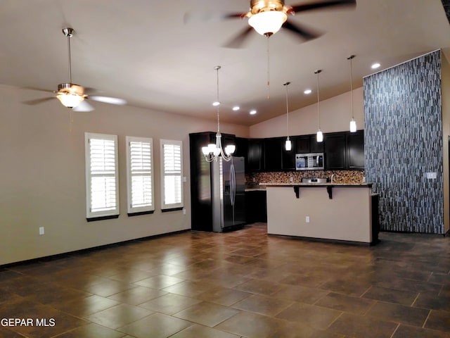 kitchen featuring a kitchen bar, open floor plan, ceiling fan with notable chandelier, and stainless steel appliances