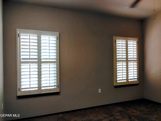 spare room featuring dark carpet