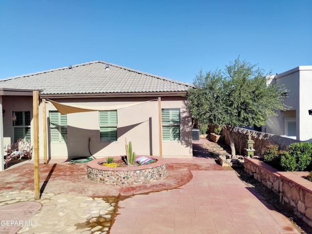 exterior space featuring a patio area, stucco siding, a tiled roof, and fence