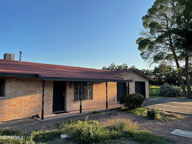 ranch-style home with a garage and central AC