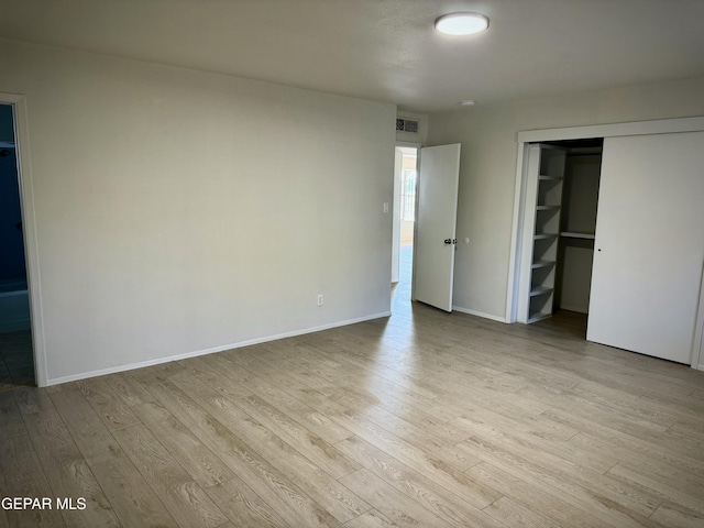 unfurnished bedroom with light hardwood / wood-style flooring and a closet