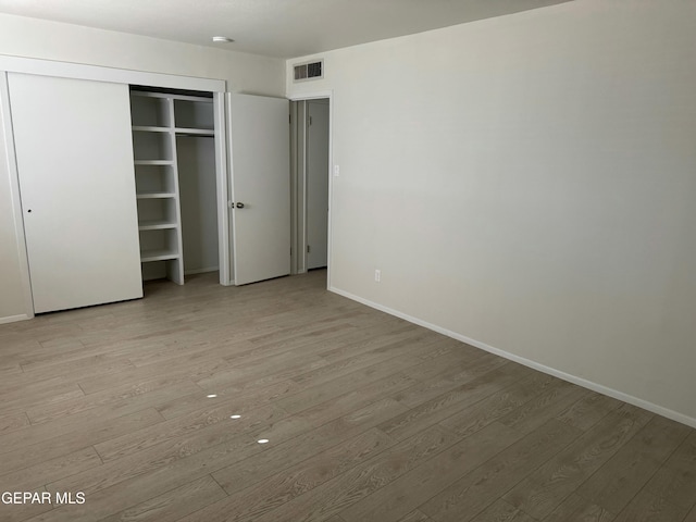 unfurnished bedroom with light hardwood / wood-style floors and a closet