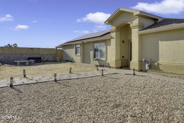 rear view of property with solar panels