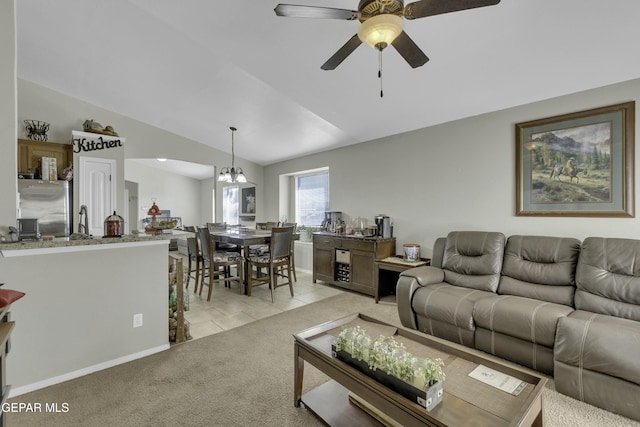 carpeted living room featuring vaulted ceiling and ceiling fan with notable chandelier