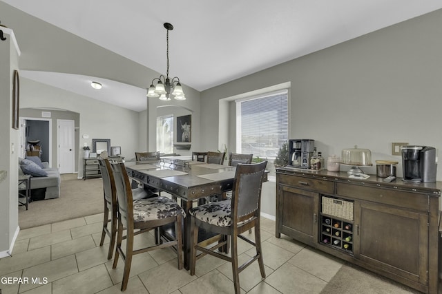 dining room with vaulted ceiling, light colored carpet, and a notable chandelier