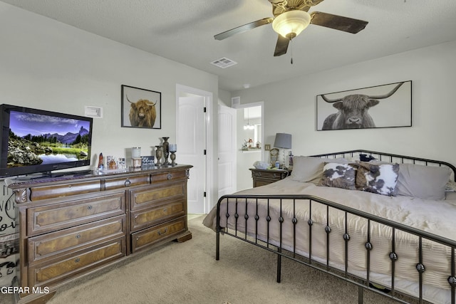 bedroom with light carpet, a textured ceiling, and ceiling fan