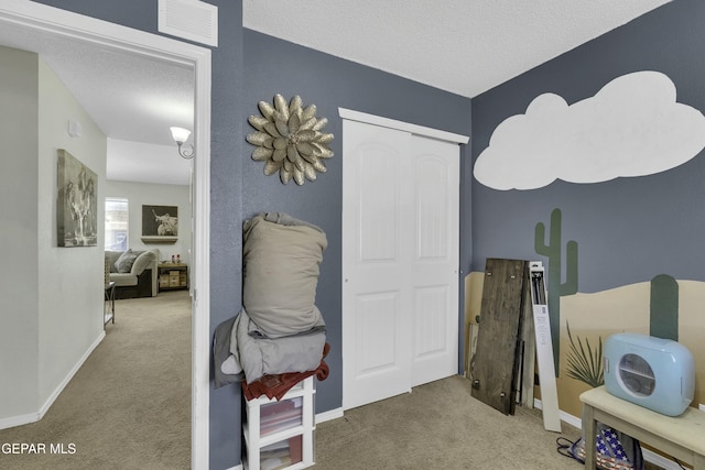 bedroom with carpet floors and a textured ceiling