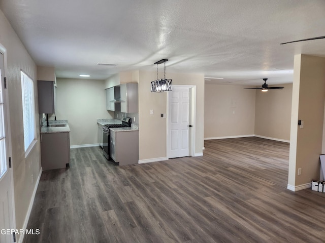 kitchen with stainless steel gas range oven, dark hardwood / wood-style floors, plenty of natural light, and gray cabinets