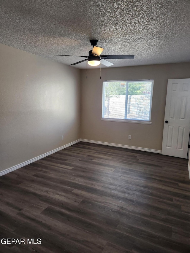 empty room with ceiling fan, dark hardwood / wood-style floors, and a textured ceiling