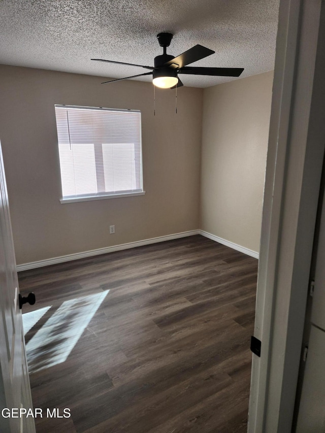 unfurnished room with dark wood-type flooring and a textured ceiling