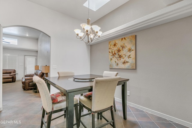 dining area featuring a notable chandelier and a skylight