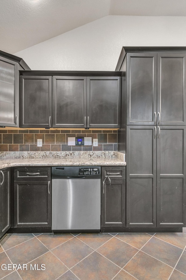 kitchen featuring a textured ceiling, stainless steel dishwasher, tasteful backsplash, and vaulted ceiling