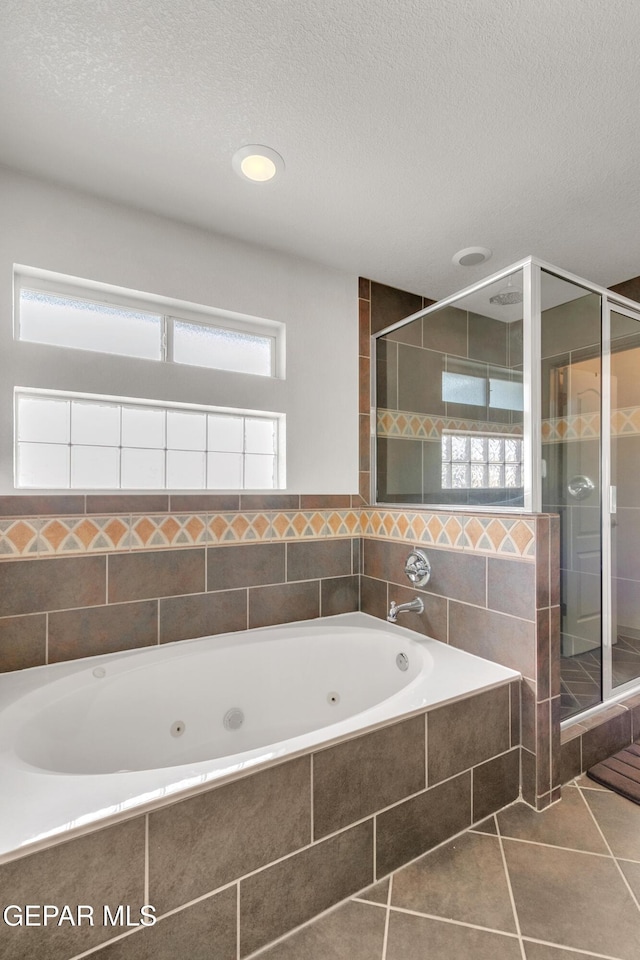 bathroom with independent shower and bath, a textured ceiling, and tile patterned flooring