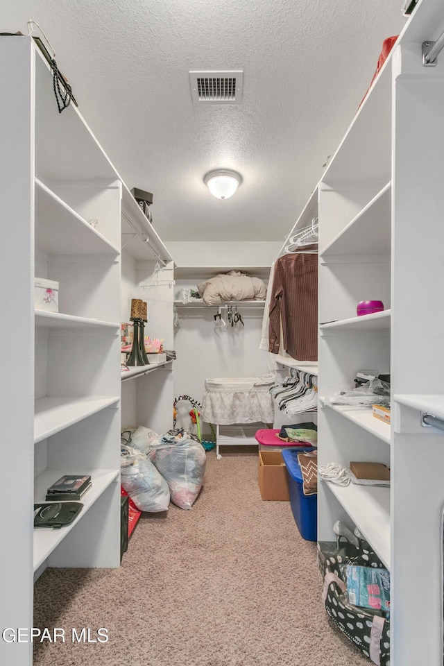 walk in closet with carpet