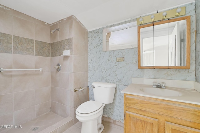 bathroom featuring a tile shower, vanity, and toilet