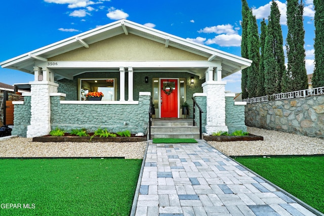 craftsman-style house featuring a porch and a front lawn