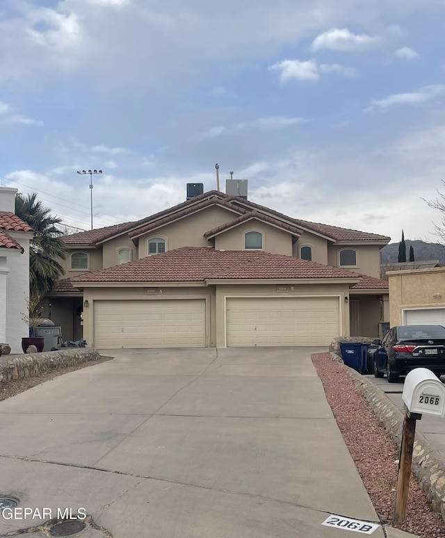 mediterranean / spanish house featuring cooling unit and a garage